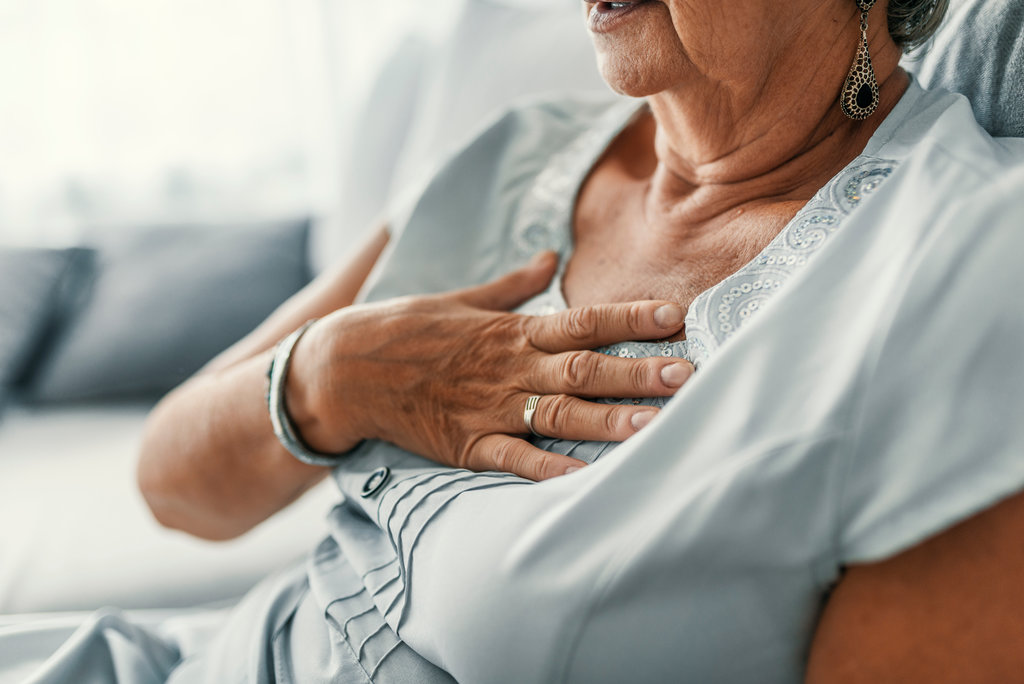 Female with chest pain. Senior woman suffering from heartburn or chest discomfort symptoms. Acid reflux or Gastroesophageal reflux disease (GERD) concept