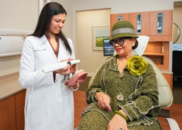 Female dentist showing model to patient at Laudenbach Periodontics