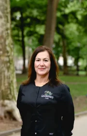 Laudenbach Periodontics & Dental Implants staff member Leta standing outdoors in park setting