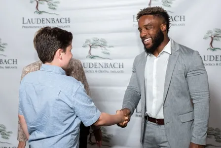 Laudenbach Periodontics Gives Back man shaking hand with a young boy